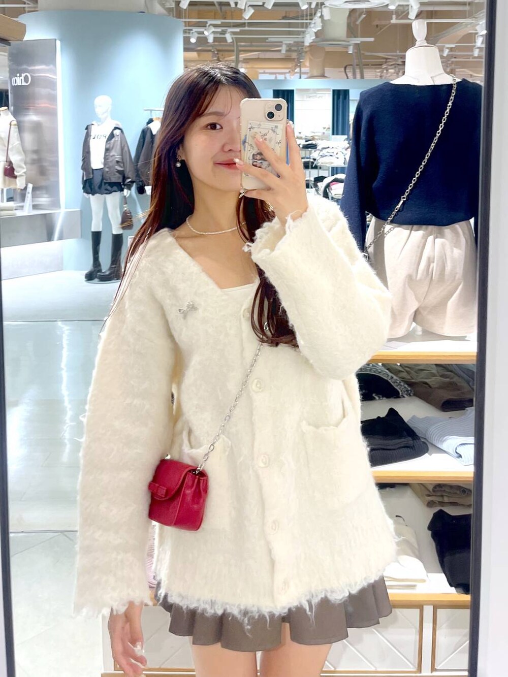 ブラウン系のスカート、ホワイト系のカーディガン/ボレロ、ベージュ系のブーツを着用したレディースの秋コーディネートの4枚目の写真