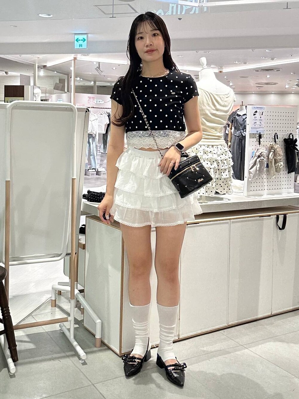 ブラック系のショルダーバッグ、ブラック系のパンプス、ホワイト系のチューブトップを着用したレディースの夏コーディネートの5枚目の写真