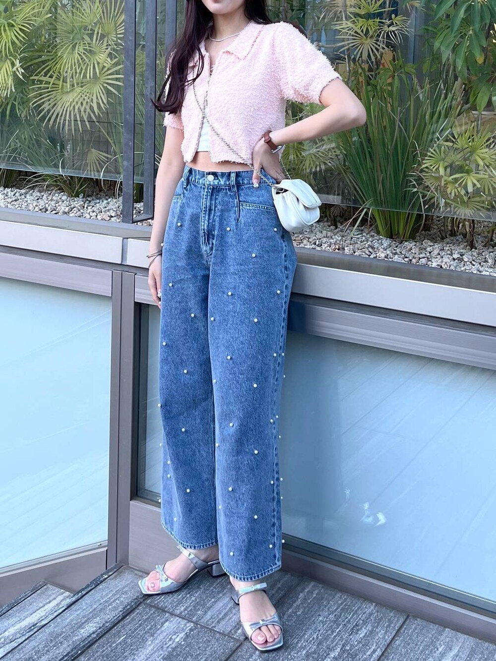 ホワイト系のショルダーバッグ、ホワイト系のキャミソール、ブルー系のデニムパンツを着用したレディースの夏コーディネートの3枚目の写真