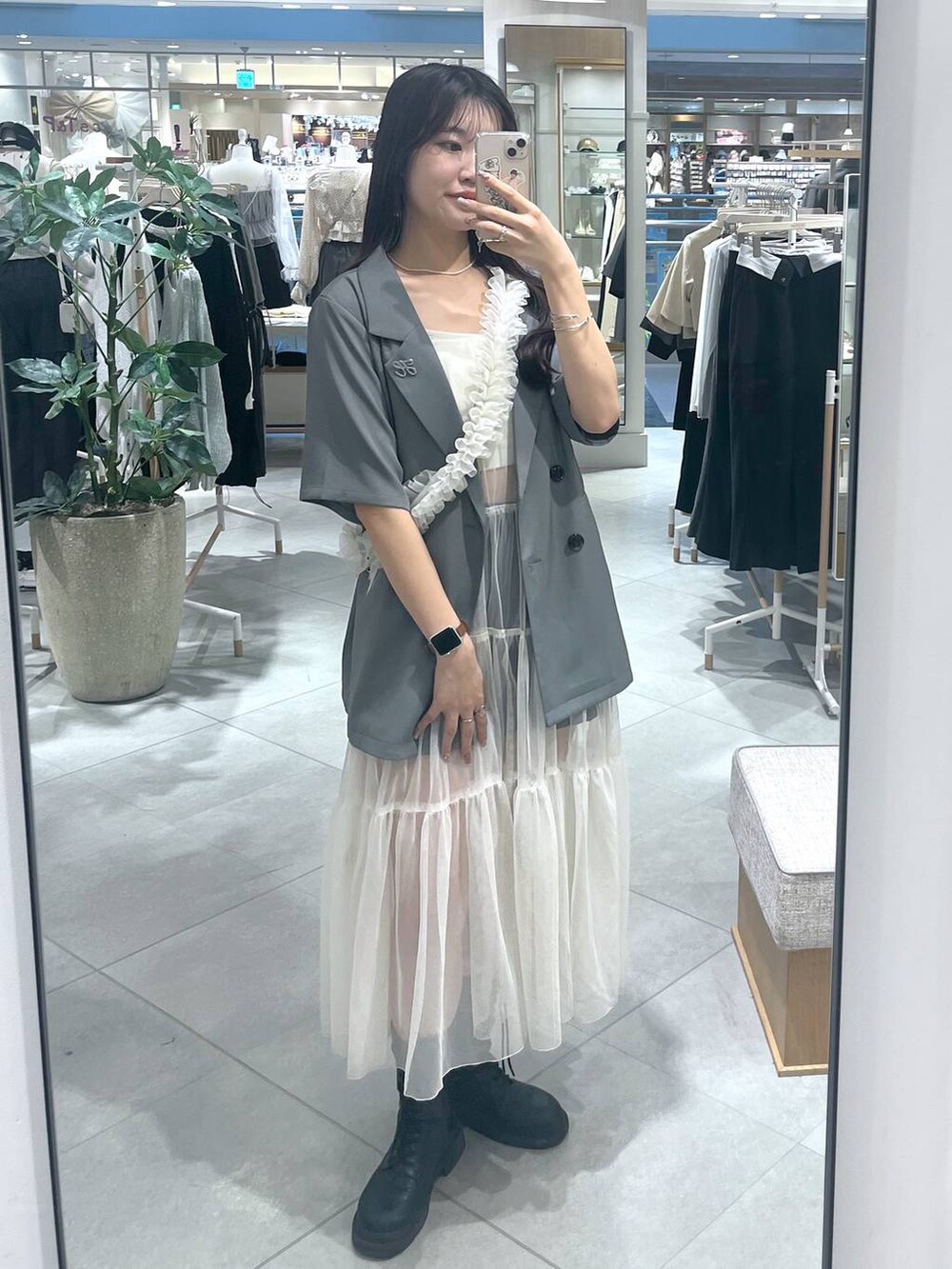 ホワイト系のワンピース、ホワイト系のキャミソール、ブラック系のブーツを着用したレディースの春コーディネートの2枚目の写真