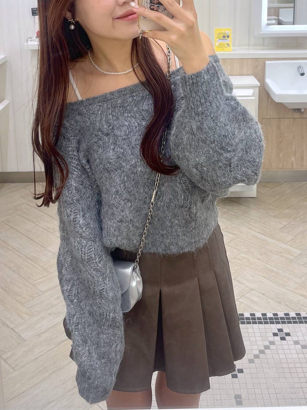 ブラウン系のスカート、ホワイト系のキャミソール、シルバー系のショルダーバッグを着用したレディースの秋コーディネートの5枚目の写真