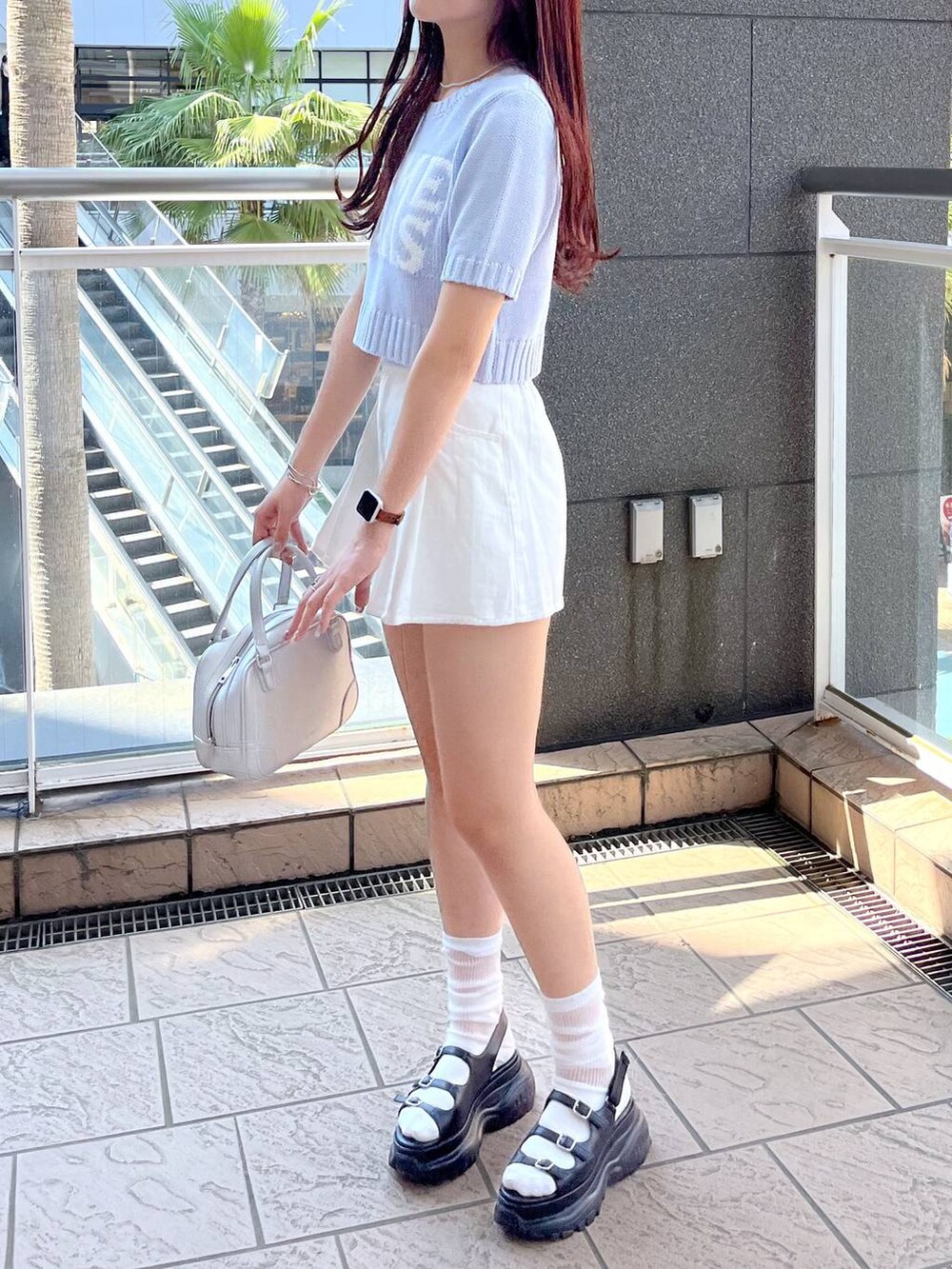 ブラック系のサンダル、ホワイト系のスカート、ブルー系のニット/セーターを着用したレディースの春コーディネートの2枚目の写真