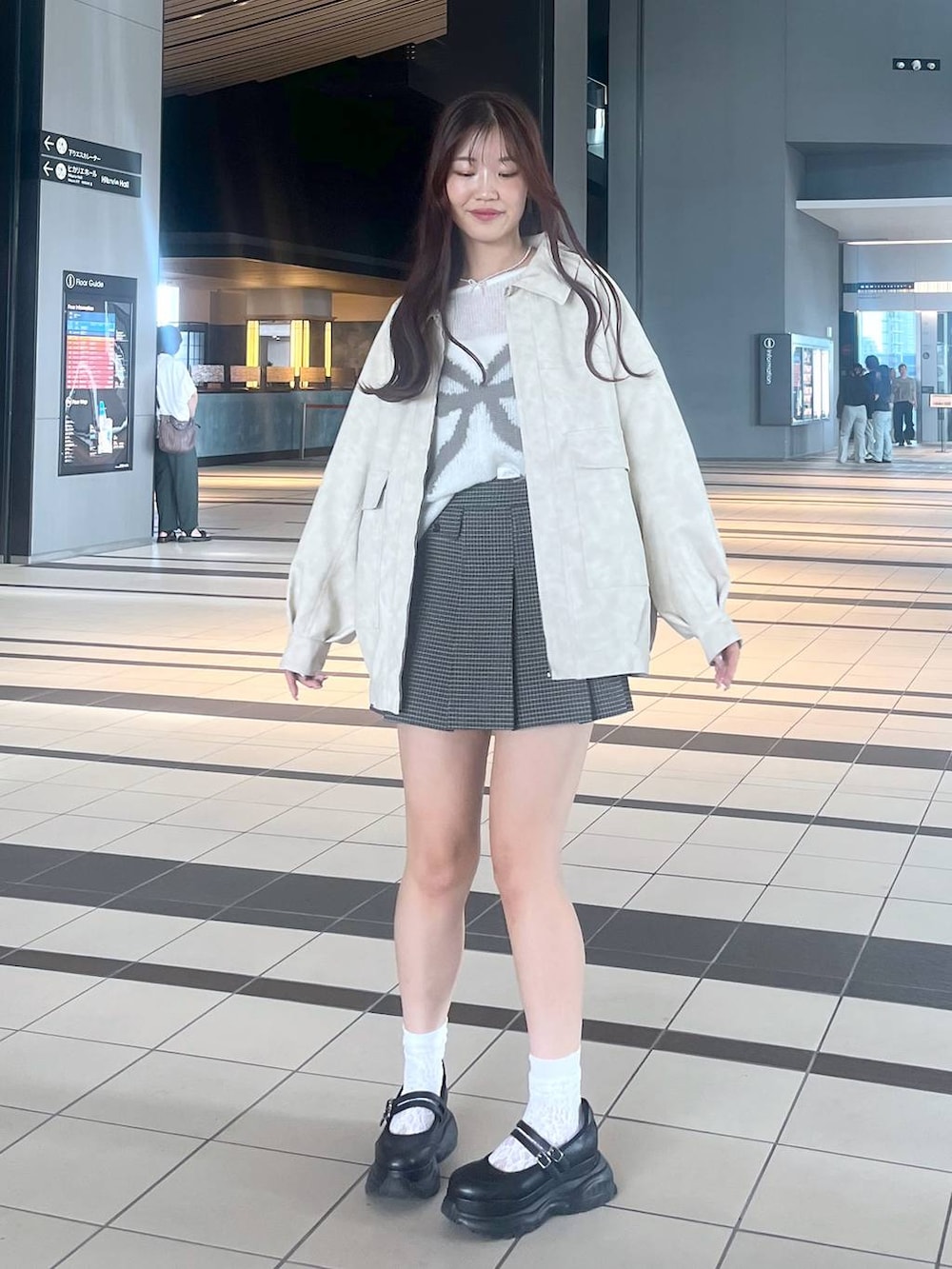 ブラック系のスニーカー、ホワイト系のキャミソール、ホワイト系のブルゾンを着用したレディースの秋コーディネートの6枚目の写真