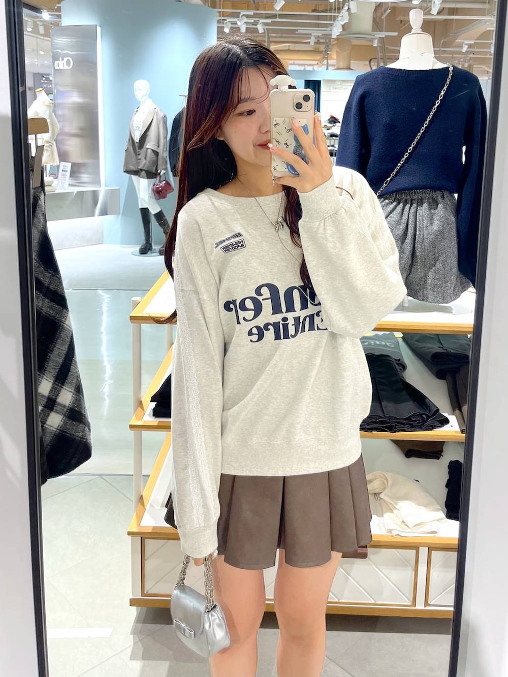 ホワイト系のTシャツ/カットソー、ブラウン系のスカート、ベージュ系のブーツを着用したレディースの冬コーディネートの3枚目の写真