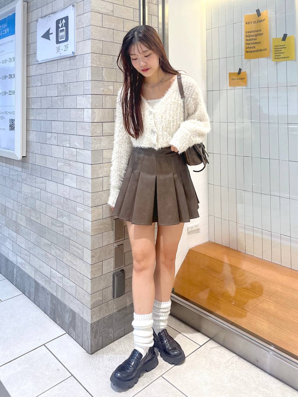 ブラウン系のショルダーバッグ、ホワイト系のアンサンブル、ホワイト系のキャミソールを着用したレディースの秋コーディネートの3枚目の写真