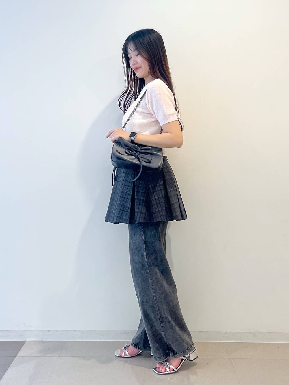 グレー系のショルダーバッグ、ホワイト系のキャミソール、グレー系のスカートを着用したレディースの春コーディネートの5枚目の写真