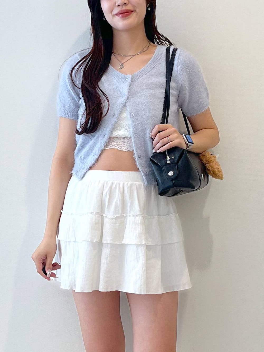 ホワイト系のスカート、ブラック系のボストンバッグ、ホワイト系のキャミソールを着用したレディースの春コーディネートの8枚目の写真