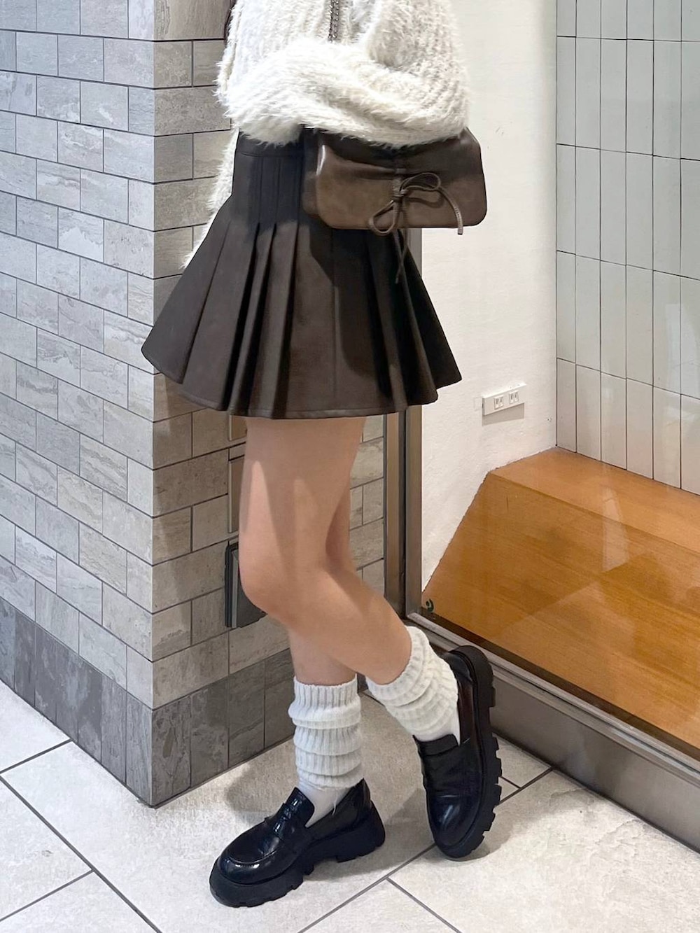 ブラウン系のショルダーバッグ、ホワイト系のアンサンブル、ホワイト系のキャミソールを着用したレディースの秋コーディネートの8枚目の写真