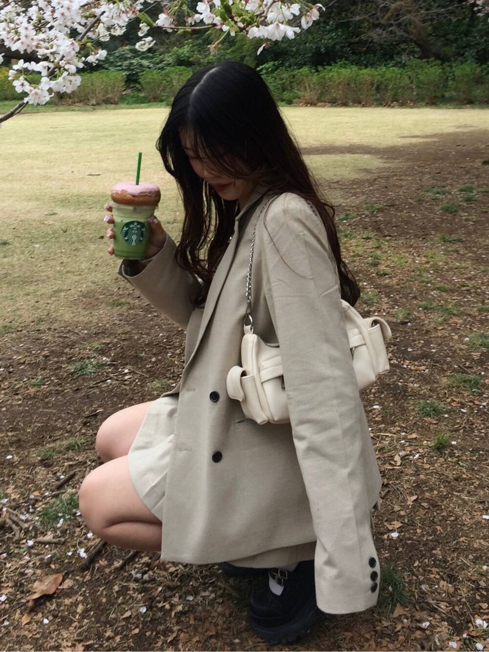 ホワイト系のキャミソール、ベージュ系のスカート、シルバー系のネックレスを着用したレディースの春コーディネートの6枚目の写真