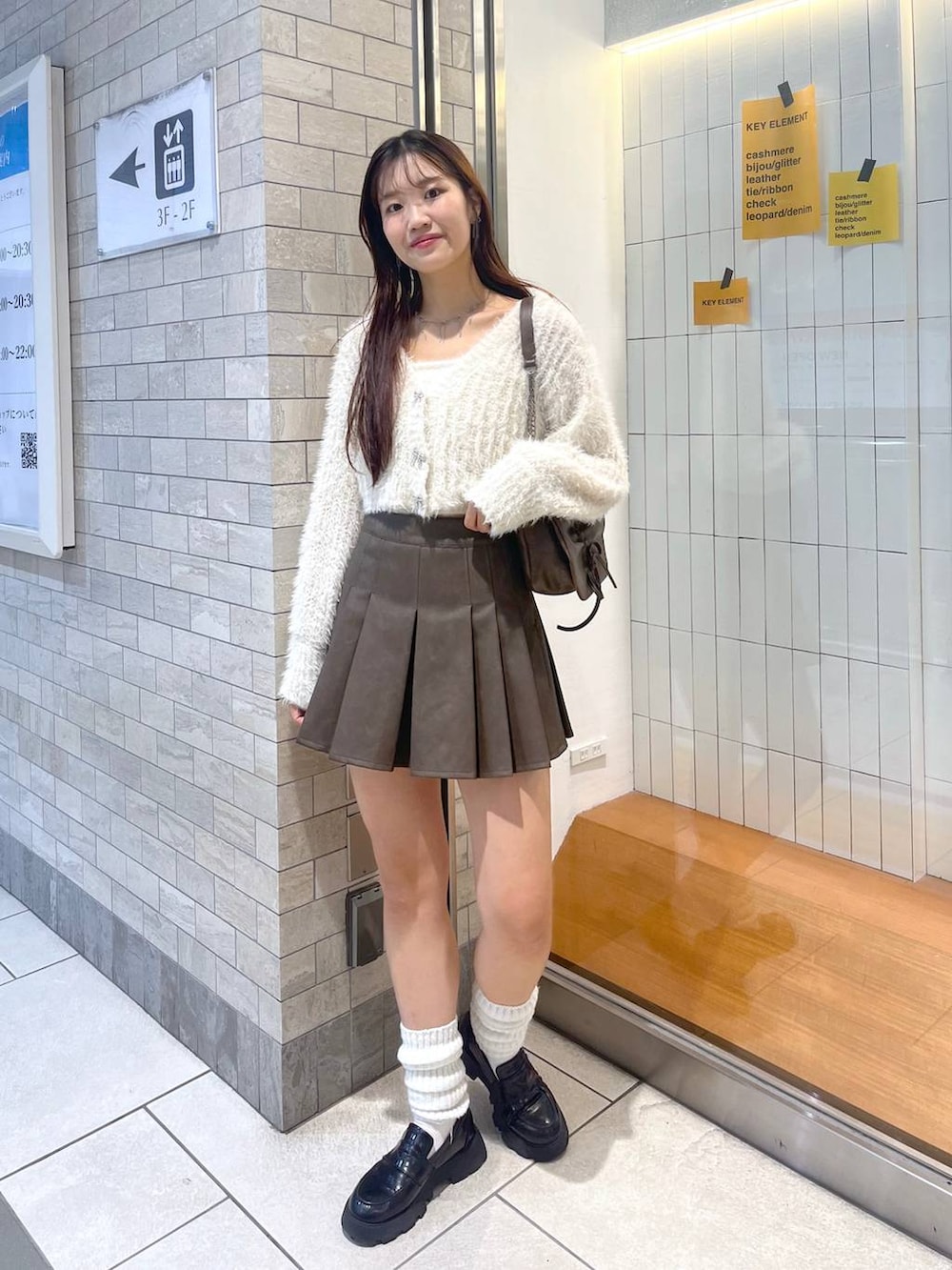 ブラウン系のショルダーバッグ、ホワイト系のアンサンブル、ホワイト系のキャミソールを着用したレディースの秋コーディネートの10枚目の写真