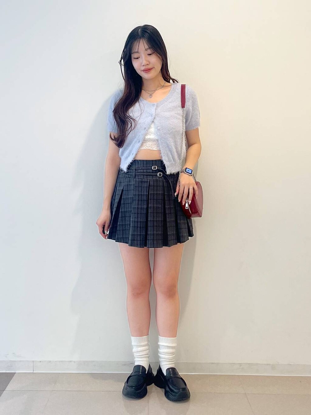 ブラック系のローファー、グレー系のスカート、レッド系のショルダーバッグを着用したレディースの春コーディネートの2枚目の写真