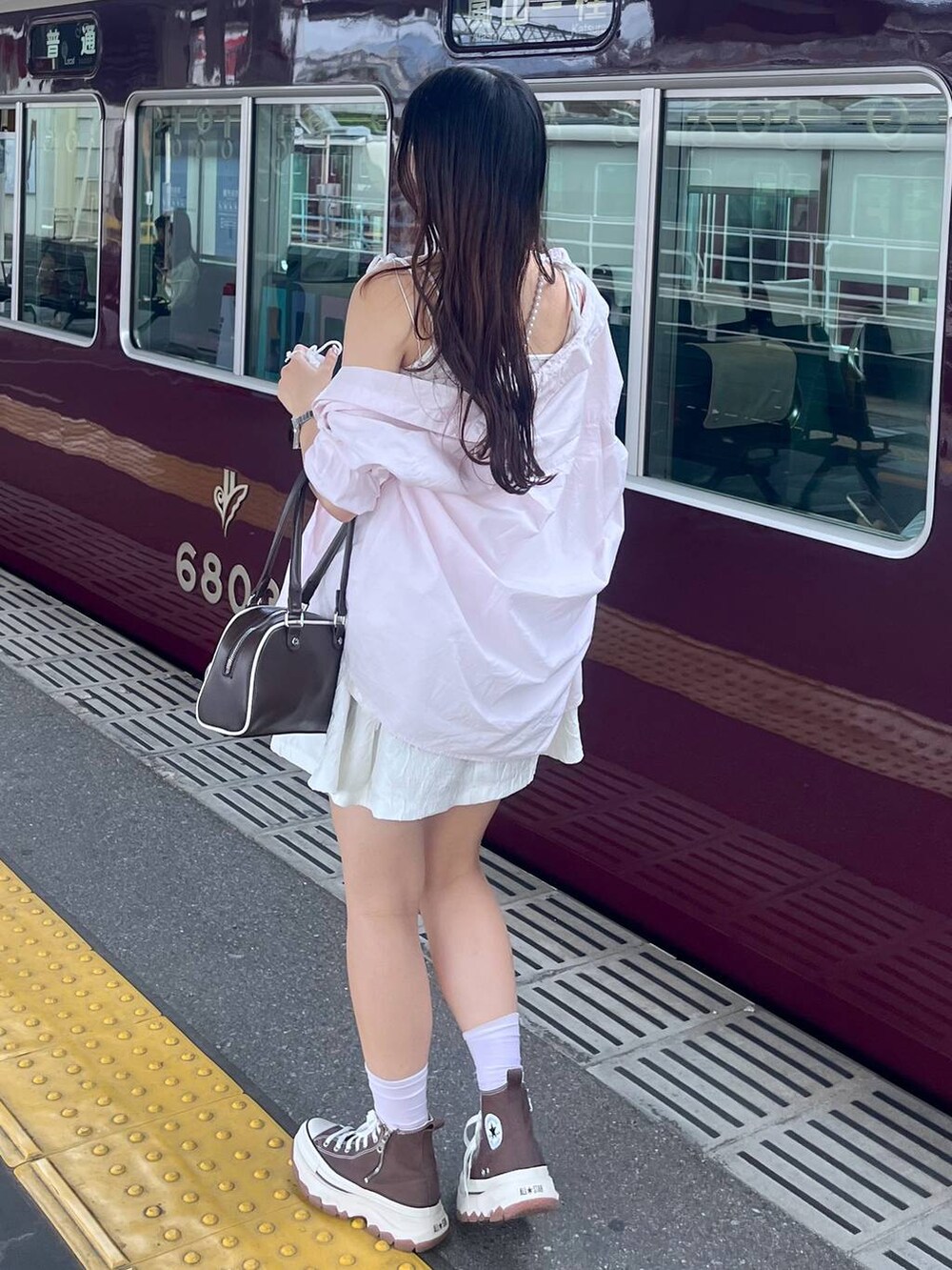 ホワイト系のワンピース、ホワイト系のカーディガン/ボレロ、ブラウン系のボストンバッグを着用したレディースの春コーディネートの4枚目の写真