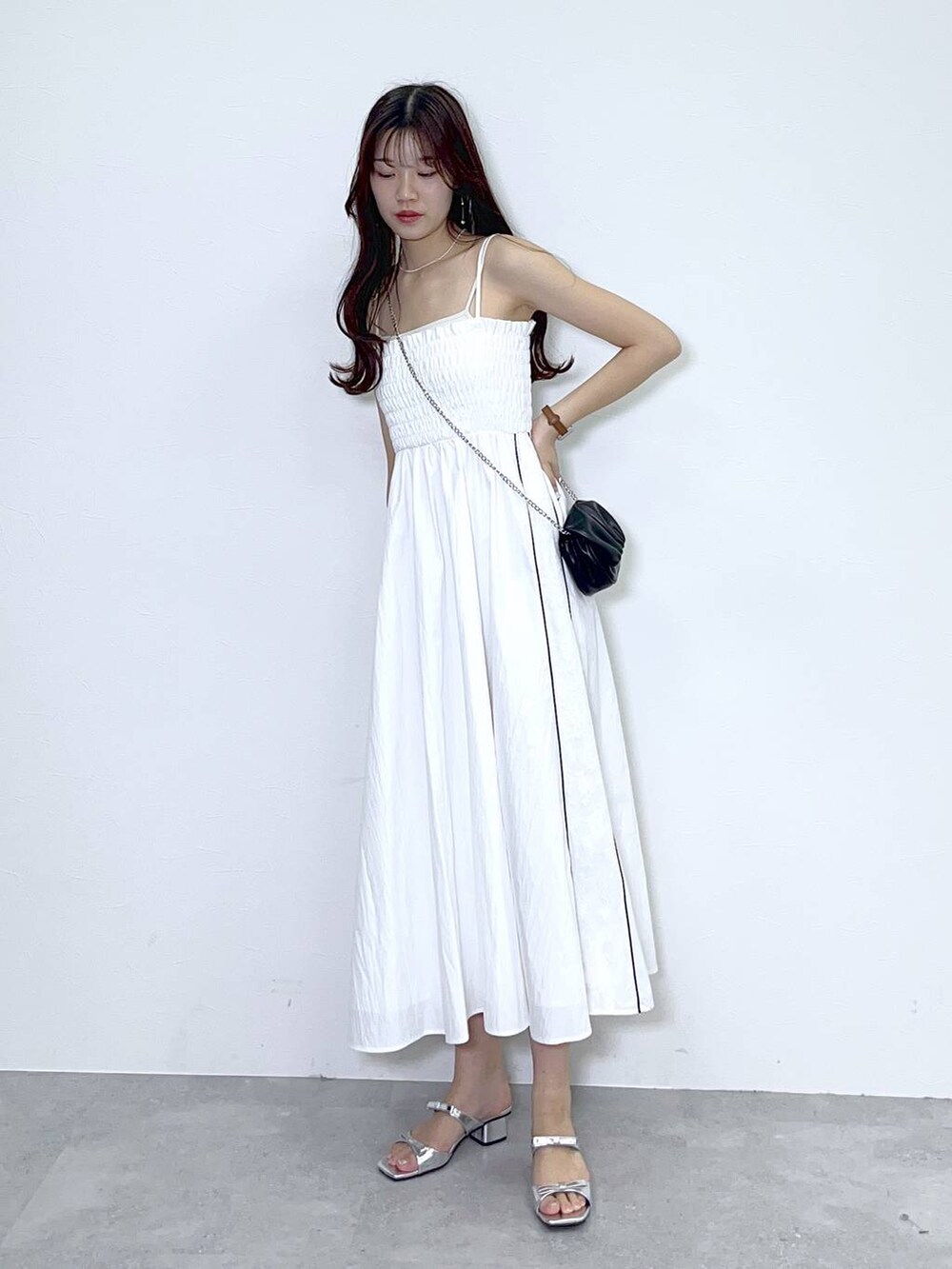 ブラック系のショルダーバッグ、ホワイト系のキャミソール、シルバー系のサンダルを着用したレディースの春コーディネートの7枚目の写真