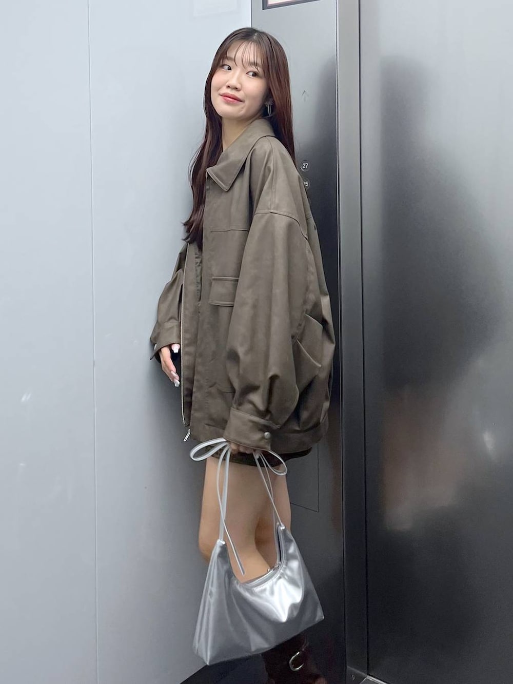 ブラウン系のブーツ、その他のスカート、ホワイト系のキャミソールを着用したレディースの秋コーディネートの5枚目の写真