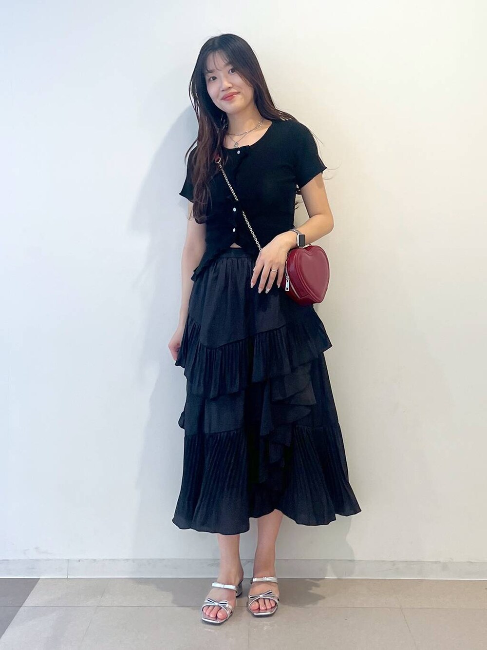 ホワイト系のキャミソール、ブラック系のスカート、シルバー系のサンダルを着用したレディースの春コーディネートの6枚目の写真