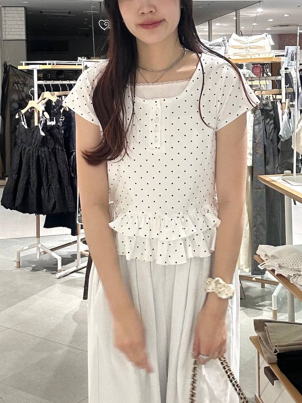 ホワイト系のパンプス、ホワイト系のチューブトップ、ブラック系のショルダーバッグを着用したレディースの春コーディネートの6枚目の写真