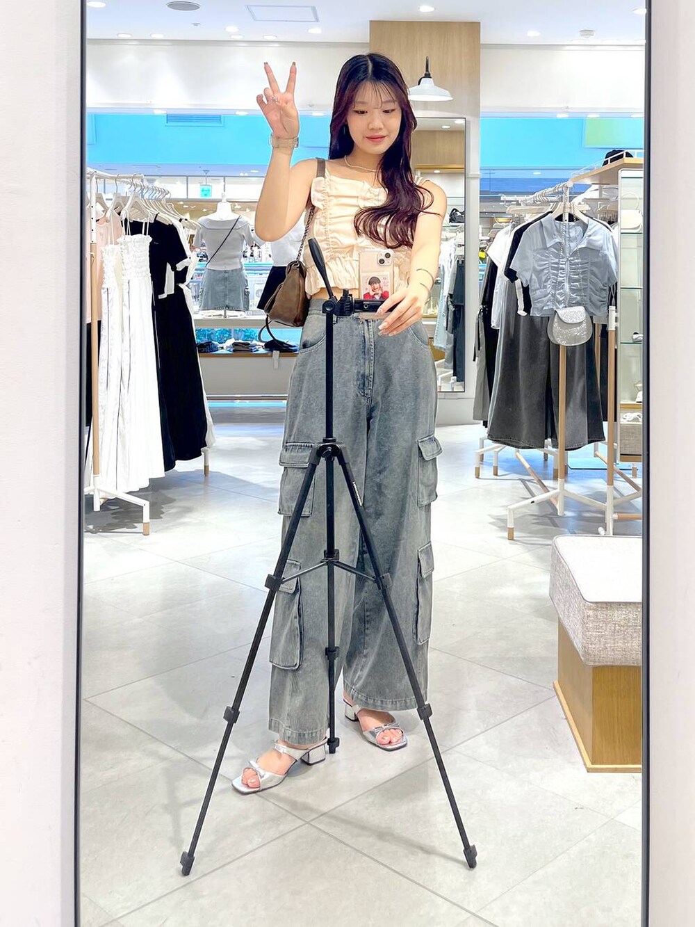 シルバー系のサンダル、ホワイト系のキャミソール、ブルー系のデニムパンツを着用したレディースの夏コーディネートの10枚目の写真