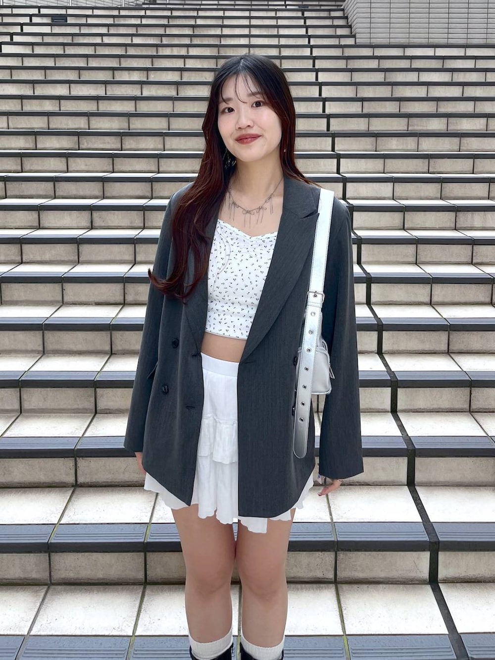 ホワイト系のキャミソール、ホワイト系のスカート、グレー系のテーラードジャケットを着用したレディースの春コーディネートの4枚目の写真