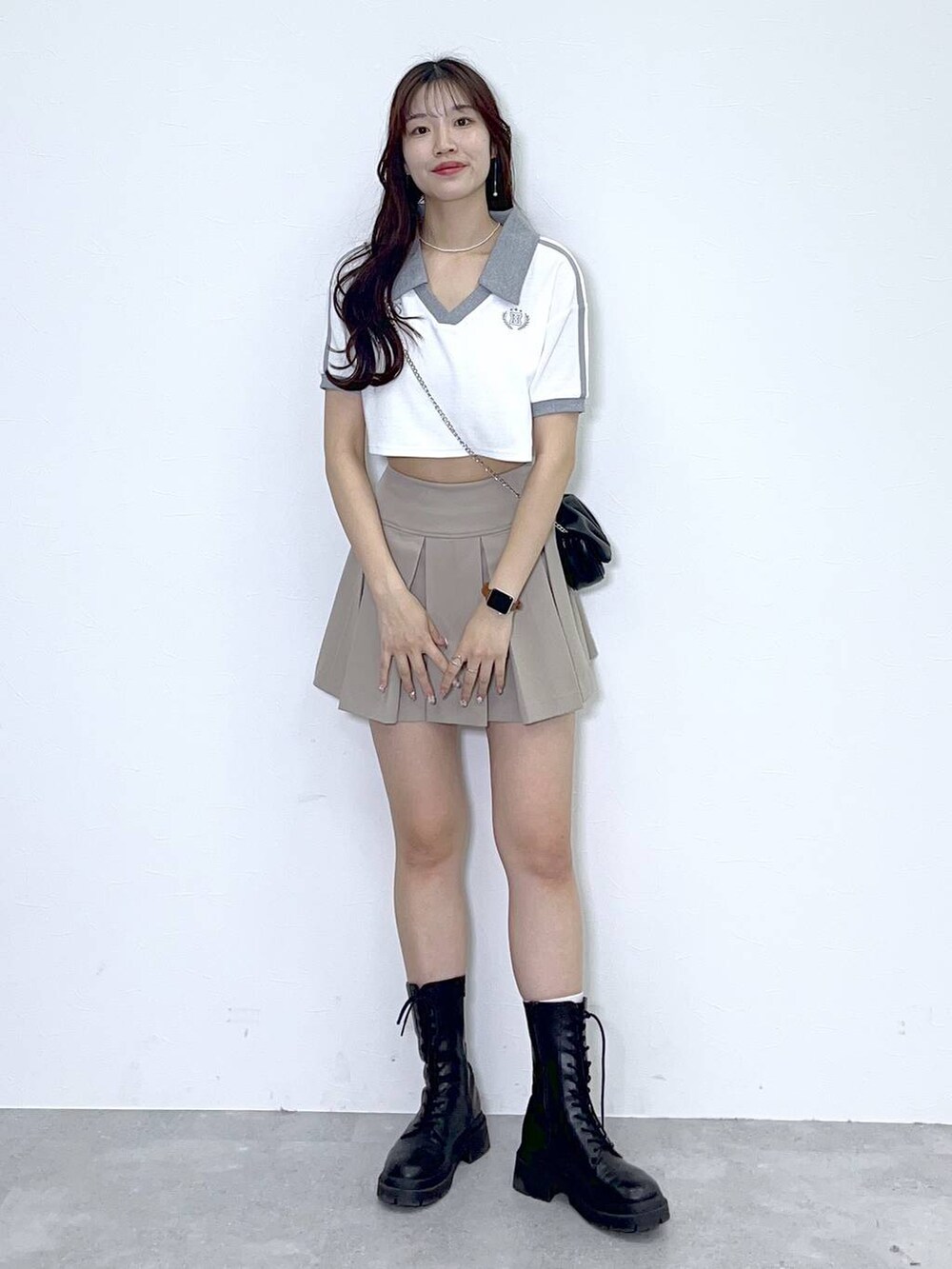 ブラック系のショルダーバッグ、ブラック系のブーツ、ホワイト系のキャミソールを着用したレディースの夏コーディネートの6枚目の写真