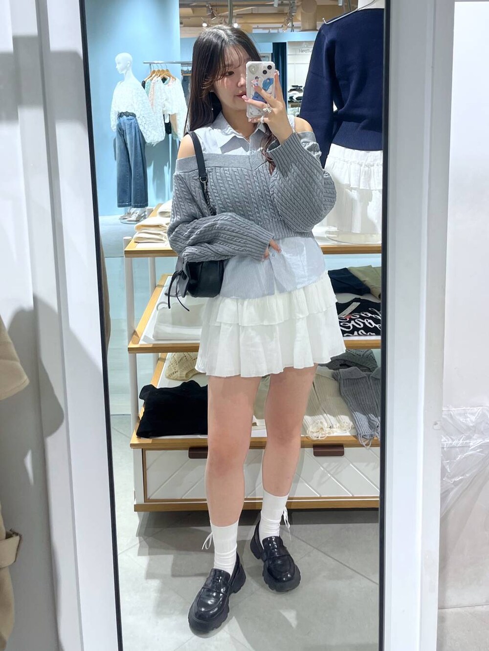 ブラック系のショルダーバッグ、ホワイト系のキャミソール、ブラック系のローファーを着用したレディースの春コーディネートの2枚目の写真