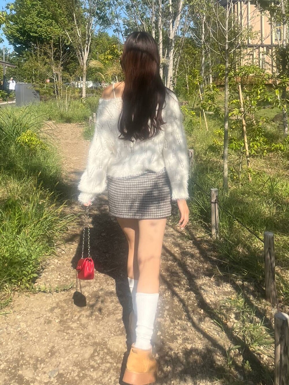 ホワイト系のニット/セーター、ホワイト系のキャミソール、ブラック系のスカートを着用したレディースの秋コーディネートの4枚目の写真