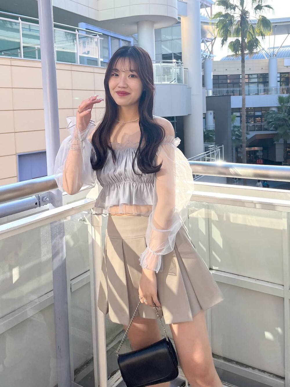 ブラック系のショルダーバッグ、グレー系のシャツ/ブラウス、ホワイト系のキャミソールを着用したレディースの春コーディネートの2枚目の写真