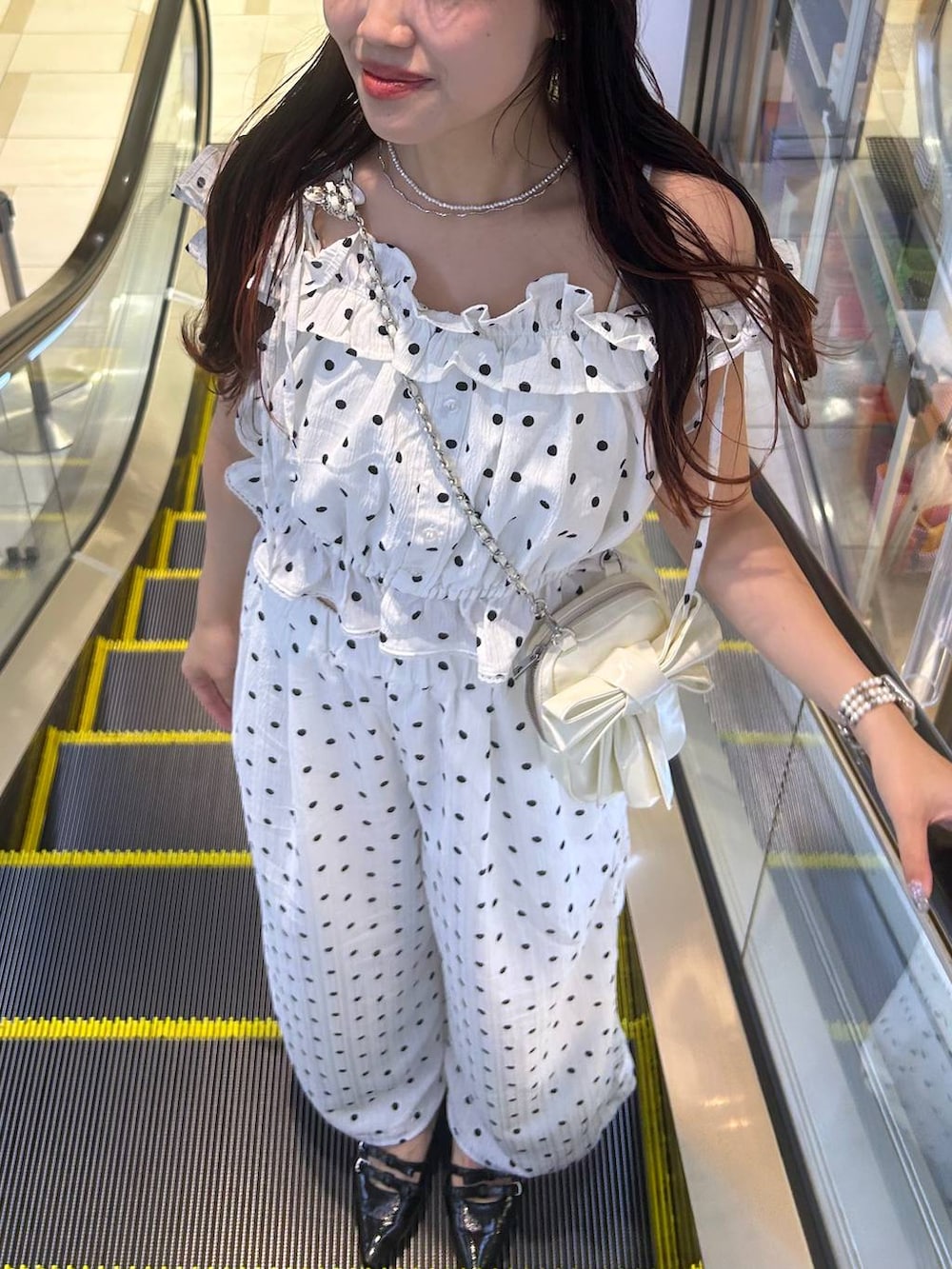 ブラック系のパンプス、ホワイト系のチューブトップ、ホワイト系のその他パンツを着用したレディースの夏コーディネートの2枚目の写真