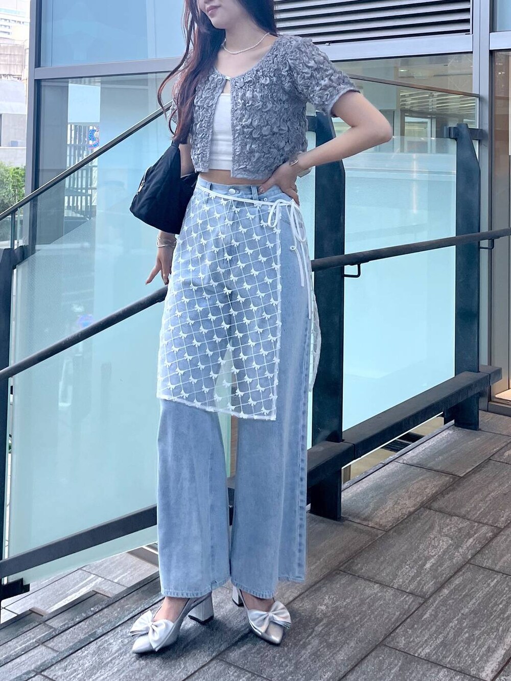 シルバー系のサンダル、ホワイト系のキャミソール、ブルー系のデニムパンツを着用したレディースの夏コーディネートの3枚目の写真