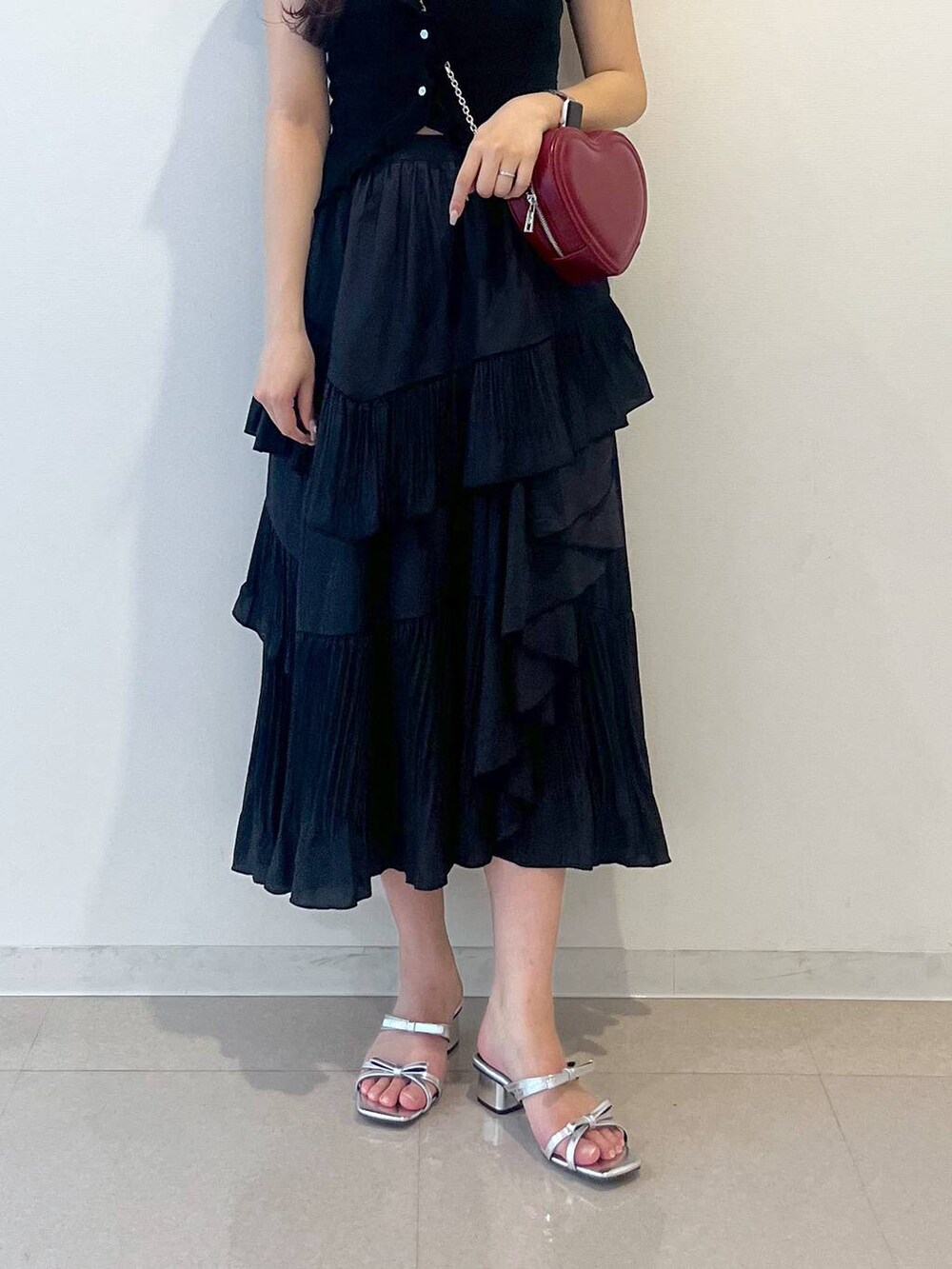 ホワイト系のキャミソール、ブラック系のスカート、シルバー系のサンダルを着用したレディースの春コーディネートの8枚目の写真