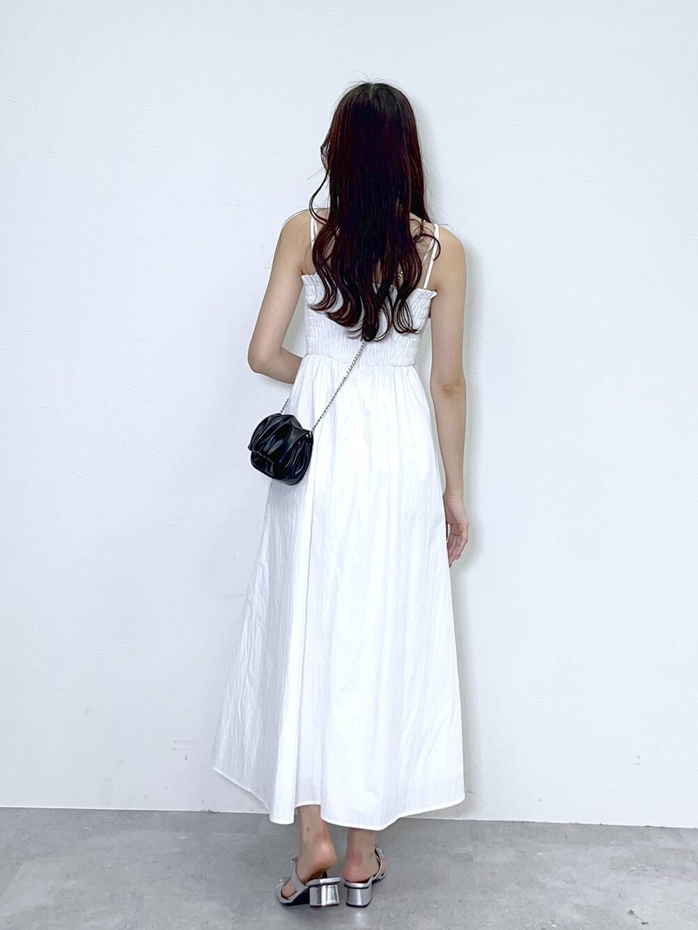 ブラック系のショルダーバッグ、ホワイト系のキャミソール、シルバー系のサンダルを着用したレディースの春コーディネートの4枚目の写真
