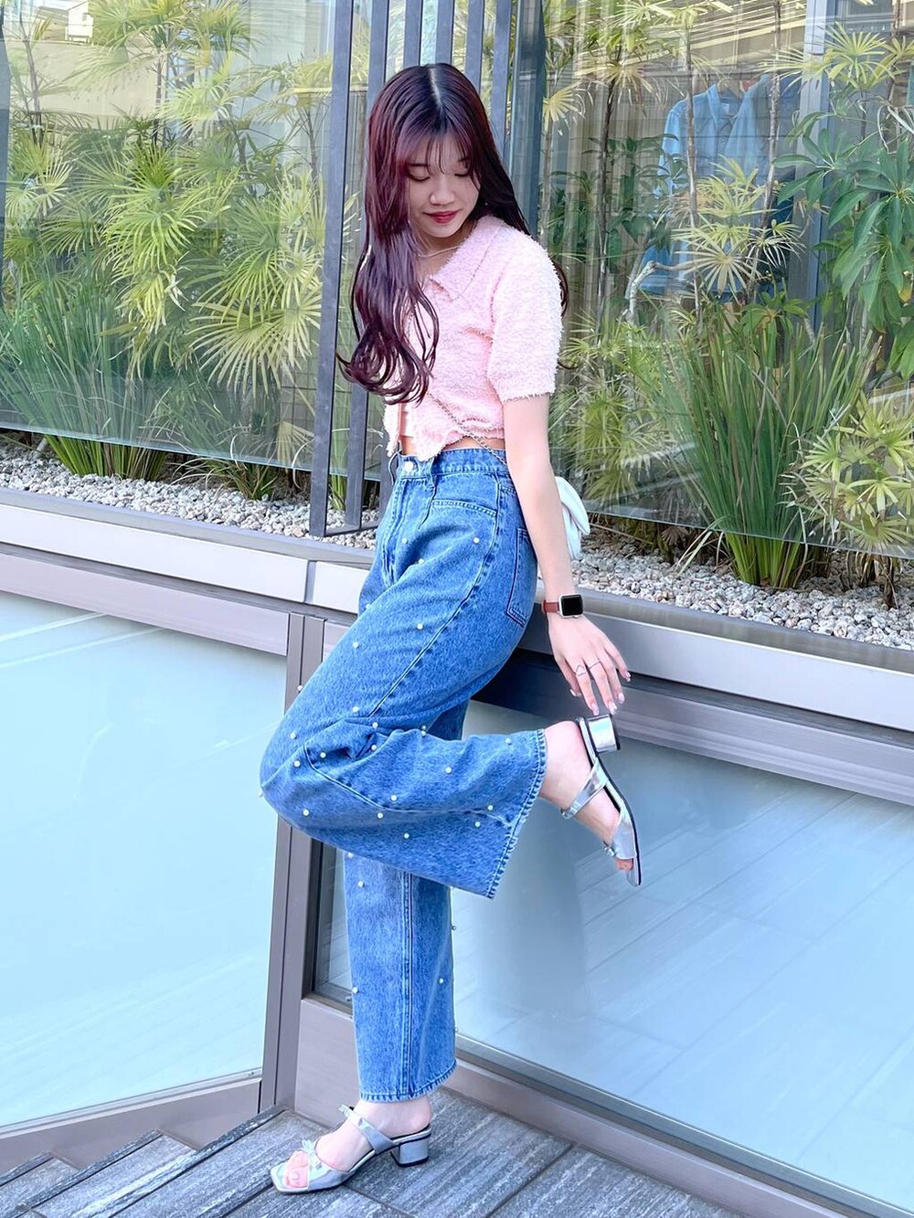 ホワイト系のショルダーバッグ、ホワイト系のキャミソール、ブルー系のデニムパンツを着用したレディースの夏コーディネートの4枚目の写真