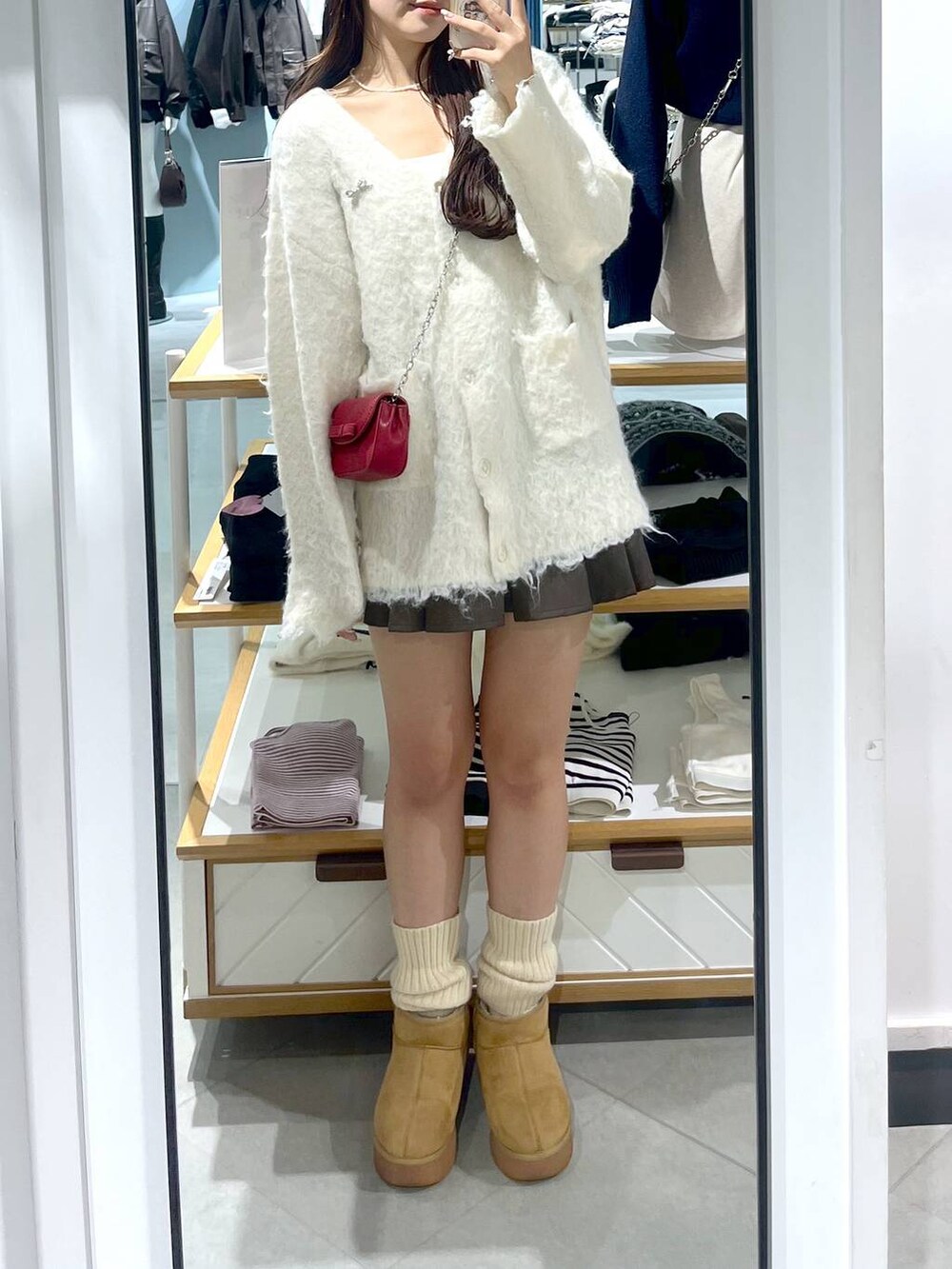 ブラウン系のスカート、ホワイト系のカーディガン/ボレロ、ベージュ系のブーツを着用したレディースの秋コーディネートの8枚目の写真