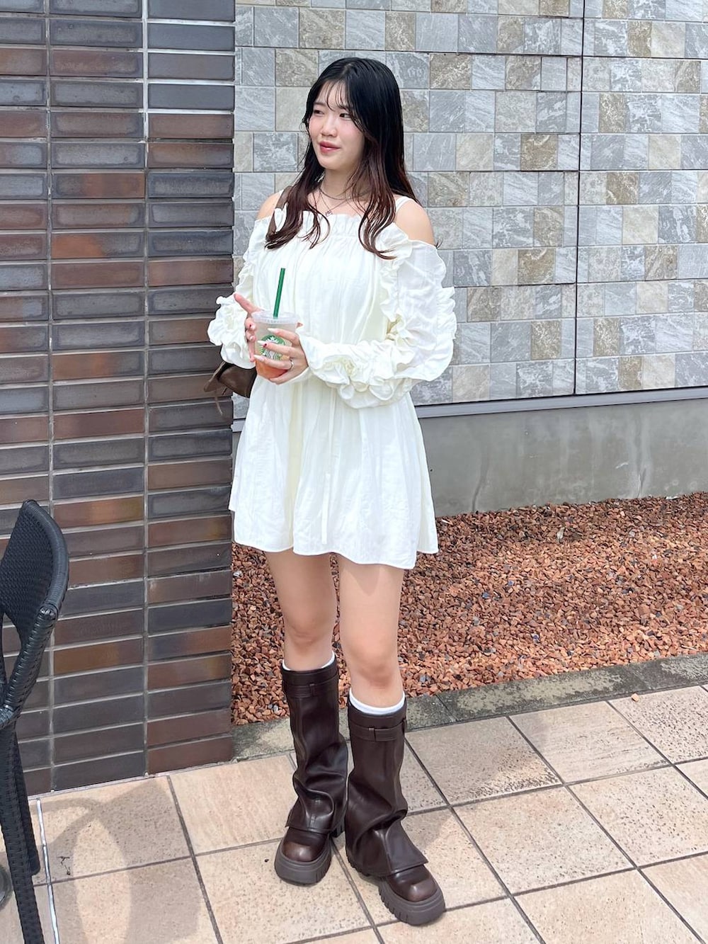 ブラウン系のショルダーバッグ、ブラウン系のブーツ、ホワイト系のキャミソールを着用したレディースの夏コーディネートの5枚目の写真