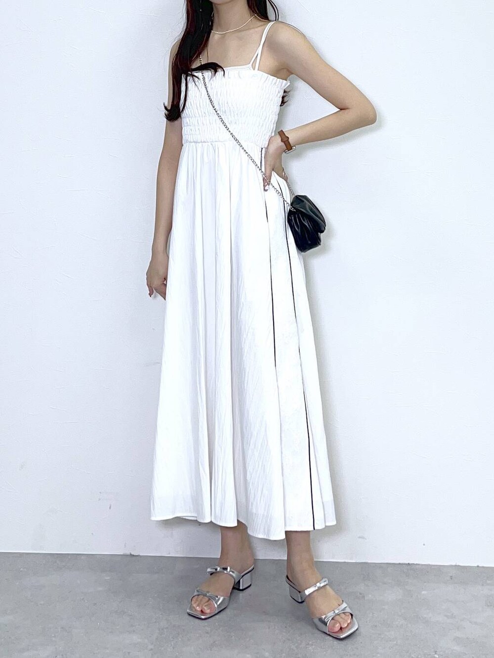 ブラック系のショルダーバッグ、シルバー系のサンダル、ホワイト系のワンピースを着用したレディースの夏コーディネートの4枚目の写真