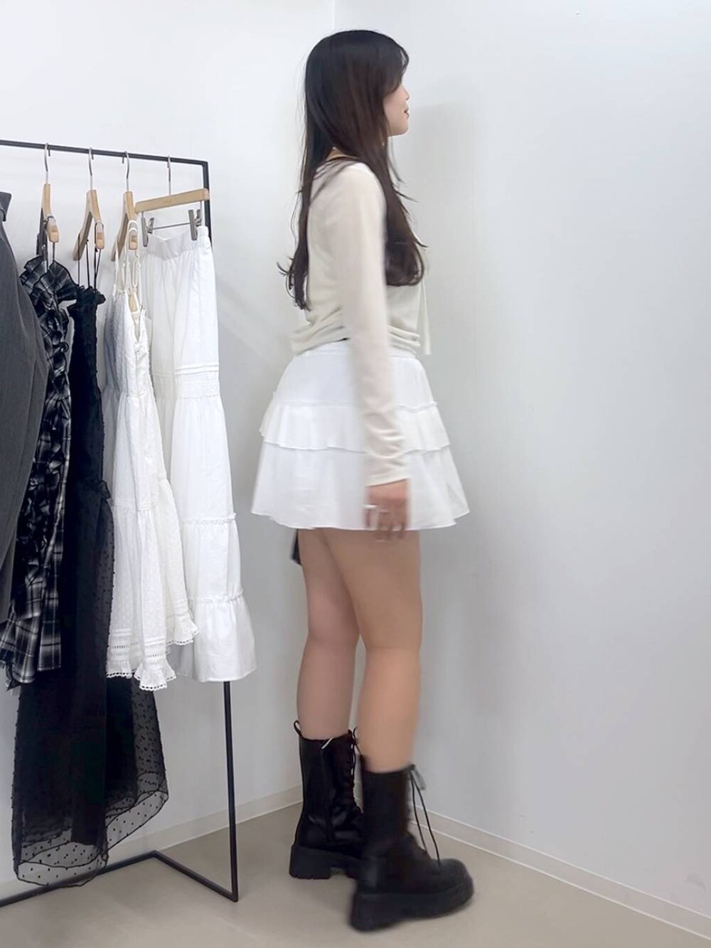 ホワイト系のキャミソール、ホワイト系のスカート、ブラック系のブーツを着用したレディースの春コーディネートの2枚目の写真