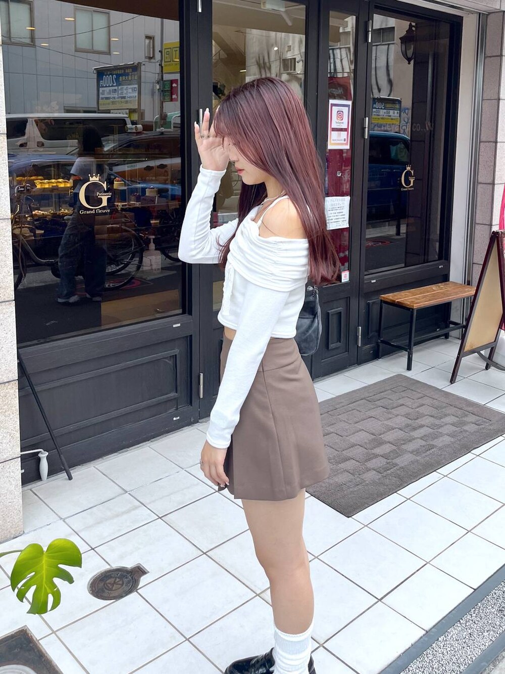 ブラウン系のスカート、グレー系のショルダーバッグ、ホワイト系のキャミソールを着用したレディースの秋コーディネートの3枚目の写真