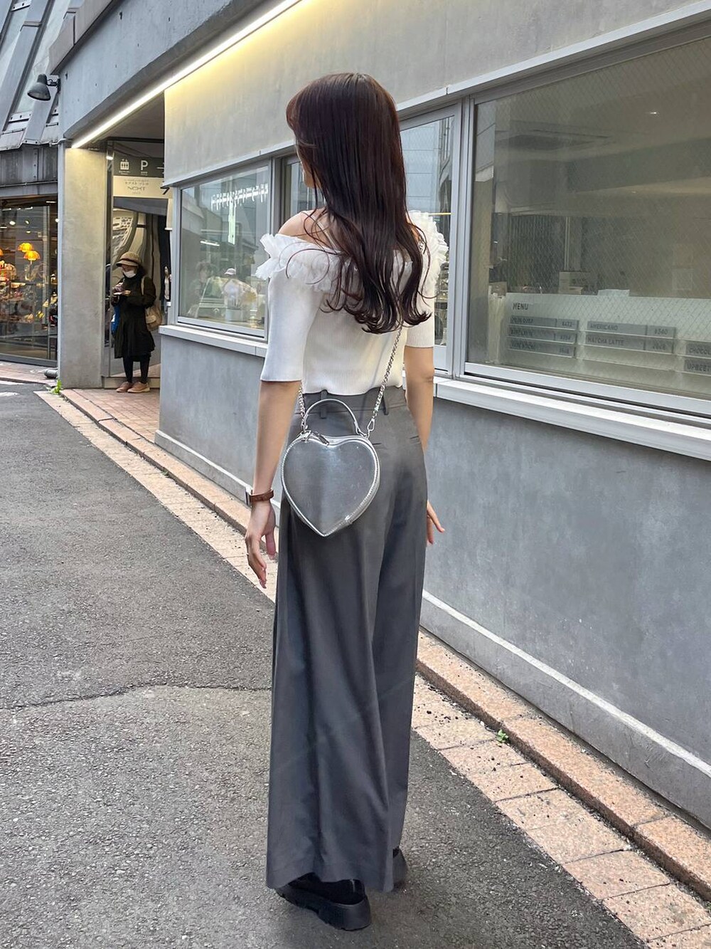 シルバー系のショルダーバッグ、ブラック系のローファー、グレー系のスラックスを着用したレディースの春コーディネートの4枚目の写真