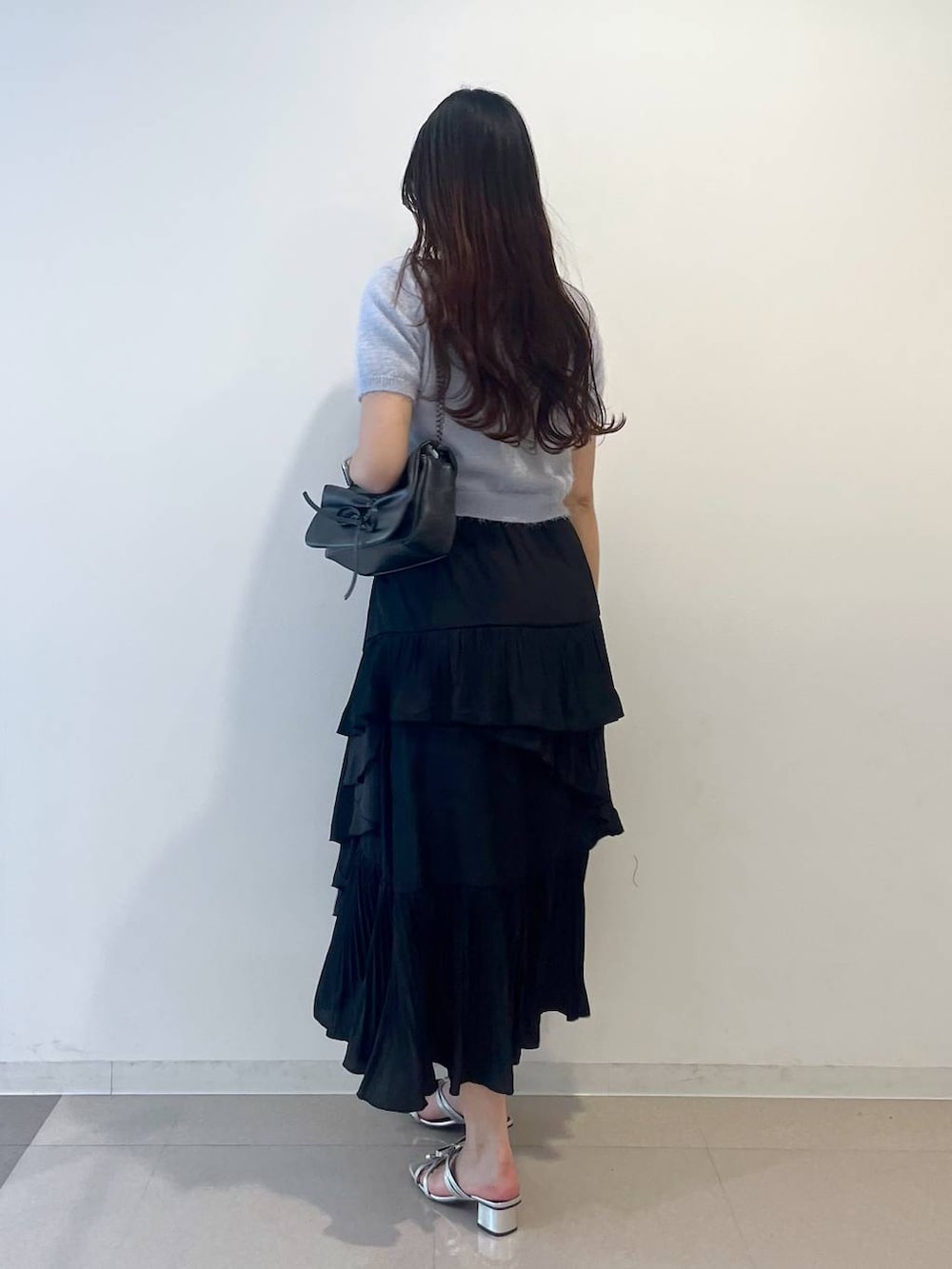 グレー系のショルダーバッグ、ブラック系のスカート、ホワイト系のキャミソールを着用したレディースの春コーディネートの4枚目の写真