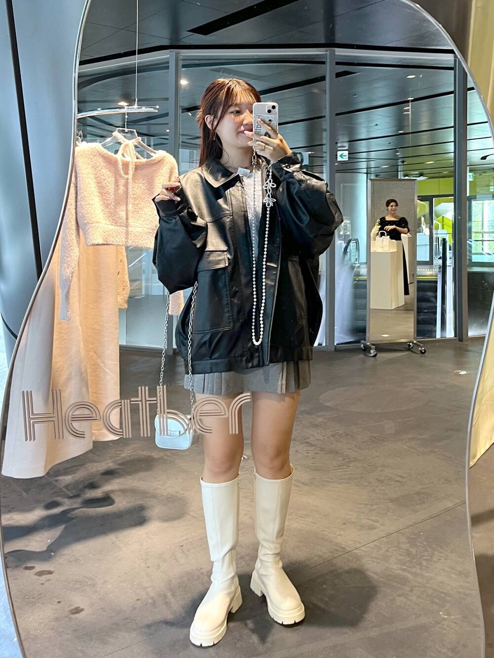 グレー系のスカート、ブルー系のカーディガン/ボレロ、ホワイト系のブーツを着用したレディースの秋コーディネートの2枚目の写真