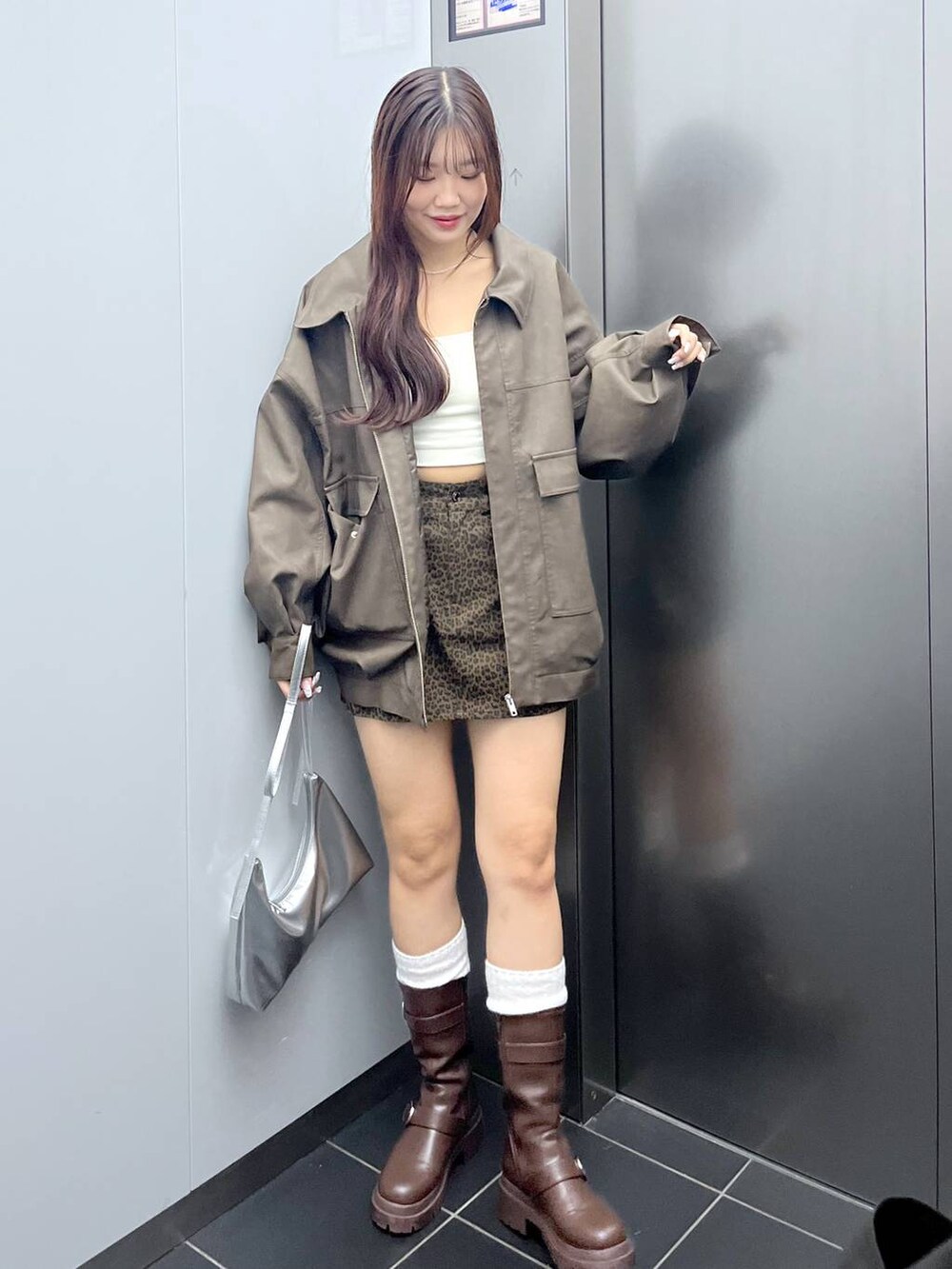 ブラウン系のブーツ、その他のスカート、ホワイト系のキャミソールを着用したレディースの秋コーディネートの7枚目の写真