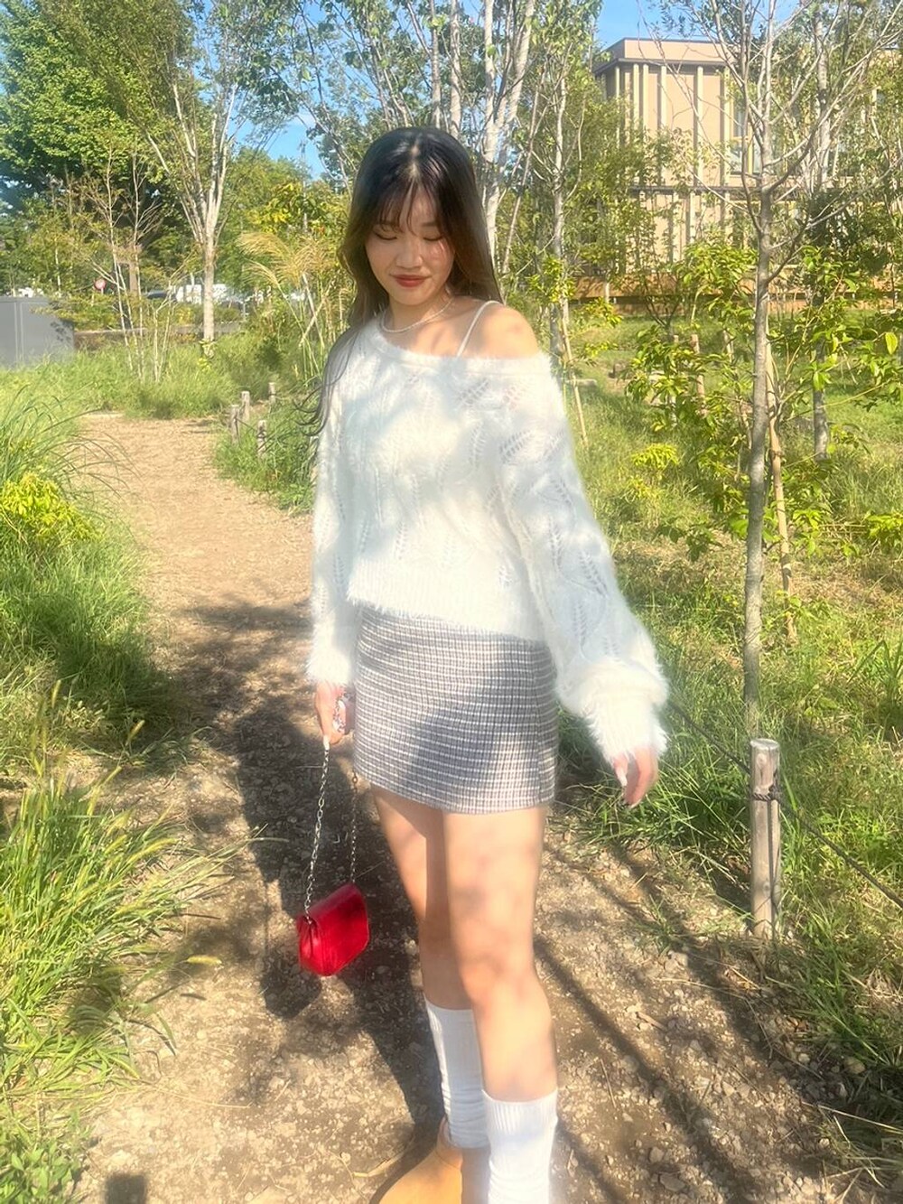 ホワイト系のニット/セーター、ホワイト系のキャミソール、ブラック系のスカートを着用したレディースの秋コーディネートの3枚目の写真