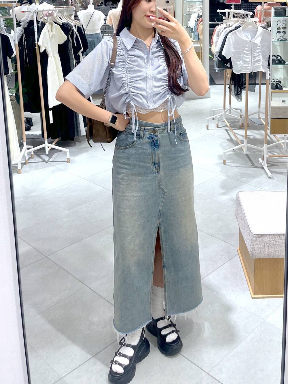 ブラウン系のショルダーバッグ、ホワイト系のキャミソール、ブラック系のサンダルを着用したレディースの夏コーディネートの3枚目の写真