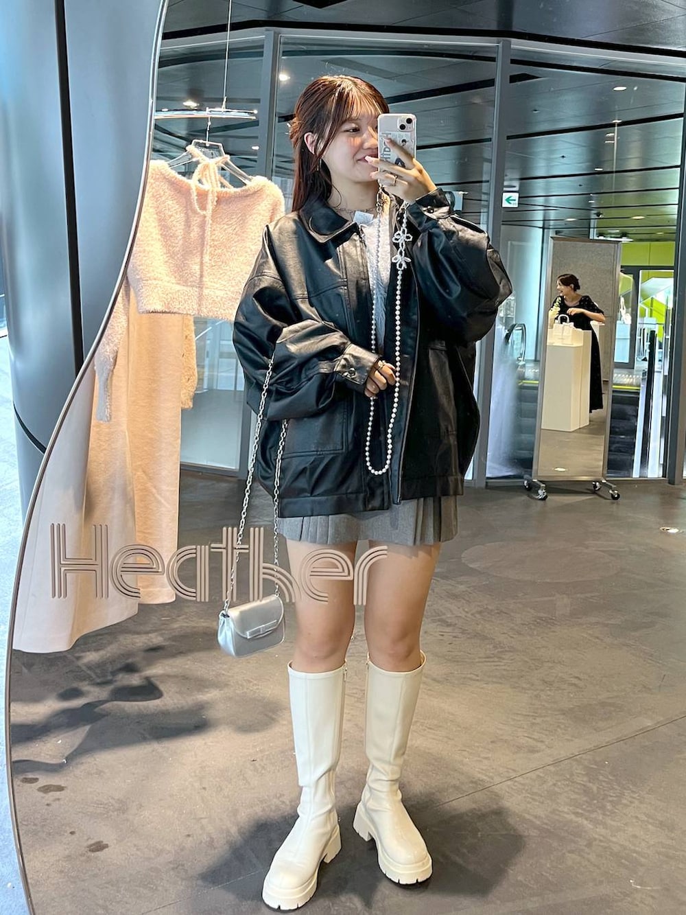 グレー系のスカート、ブルー系のカーディガン/ボレロ、ホワイト系のブーツを着用したレディースの秋コーディネートの9枚目の写真