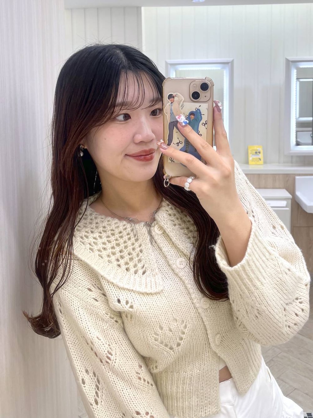 ホワイト系のキャミソール、ホワイト系のスカート、ホワイト系のカーディガン/ボレロを着用したレディースの冬コーディネートの4枚目の写真