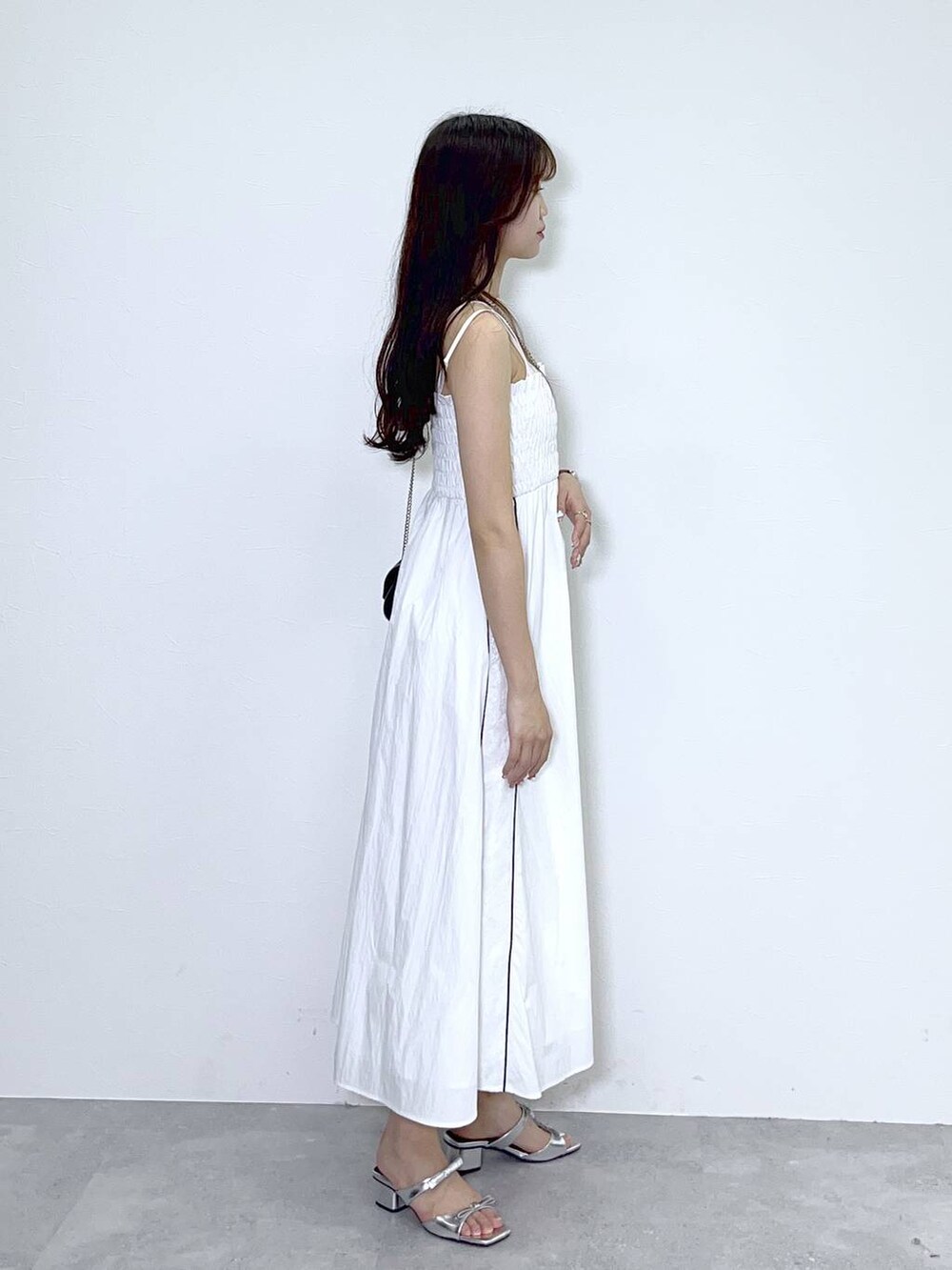 ブラック系のショルダーバッグ、ホワイト系のキャミソール、シルバー系のサンダルを着用したレディースの春コーディネートの3枚目の写真