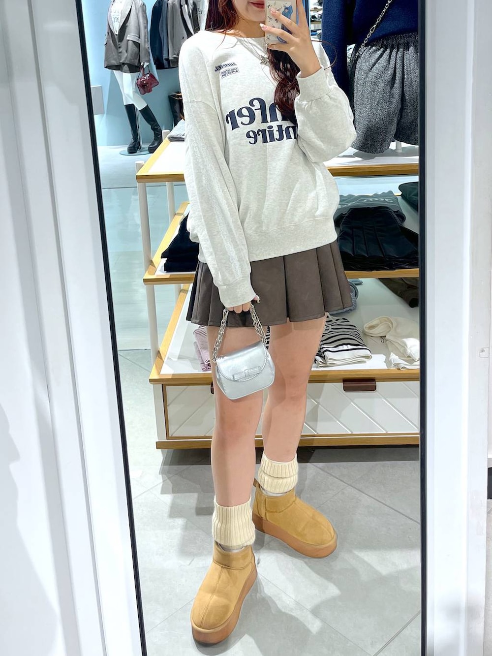 ホワイト系のTシャツ/カットソー、ブラウン系のスカート、ベージュ系のブーツを着用したレディースの冬コーディネートの9枚目の写真