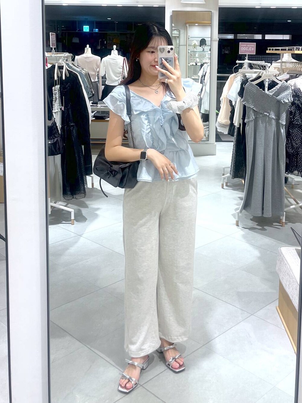 グレー系のショルダーバッグ、ホワイト系のキャミソール、シルバー系のサンダルを着用したレディースの春コーディネートの2枚目の写真