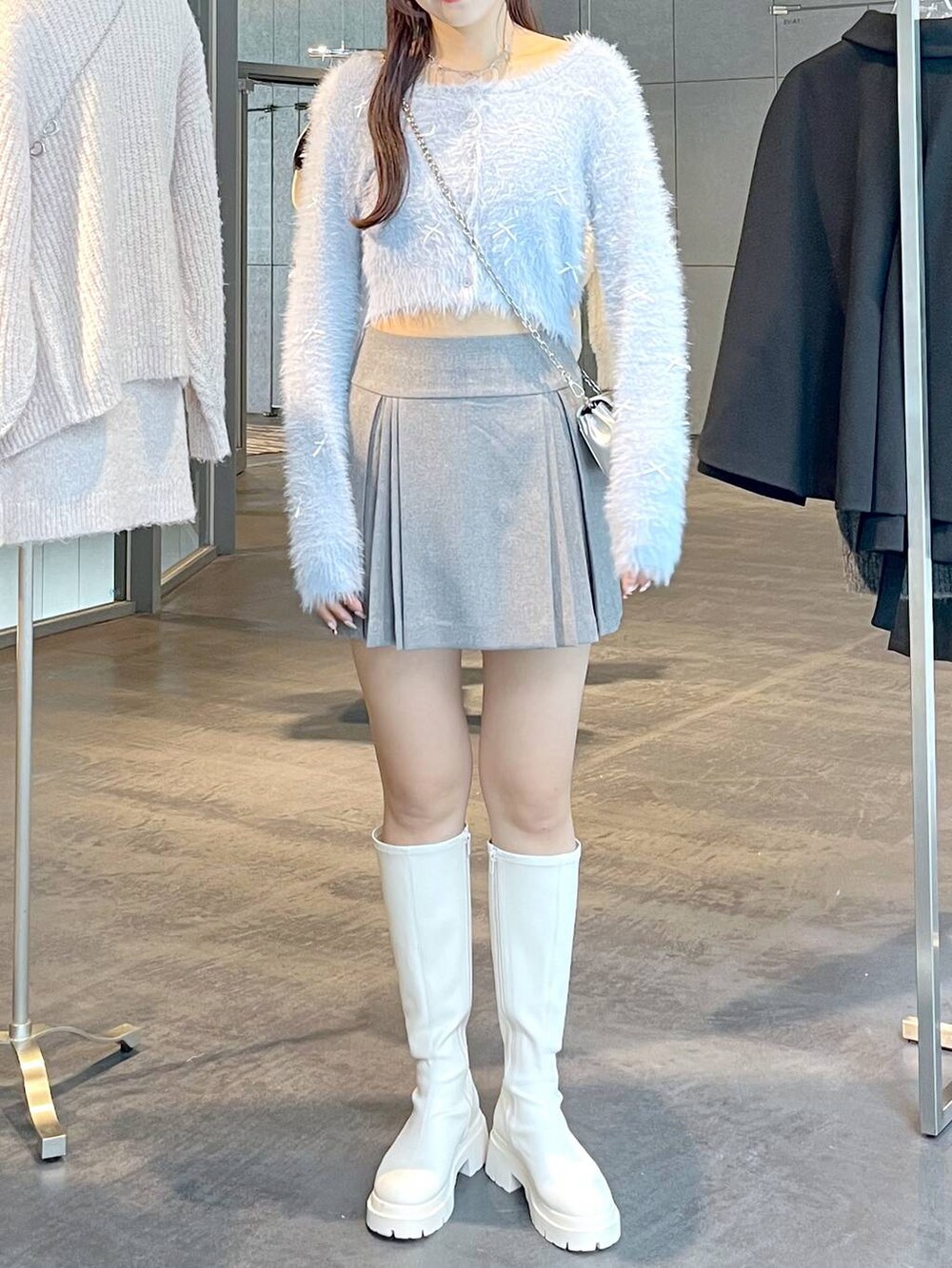 グレー系のスカート、ホワイト系のブーツ、ホワイト系のTシャツ/カットソーを着用したレディースの秋コーディネートの5枚目の写真