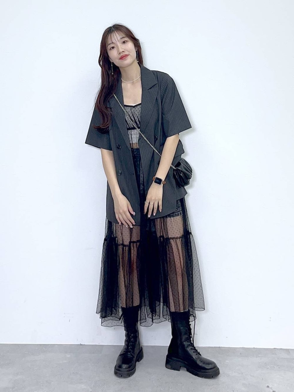 ブラック系のショルダーバッグ、ホワイト系のキャミソール、ブラック系のブーツを着用したレディースの夏コーディネートの5枚目の写真