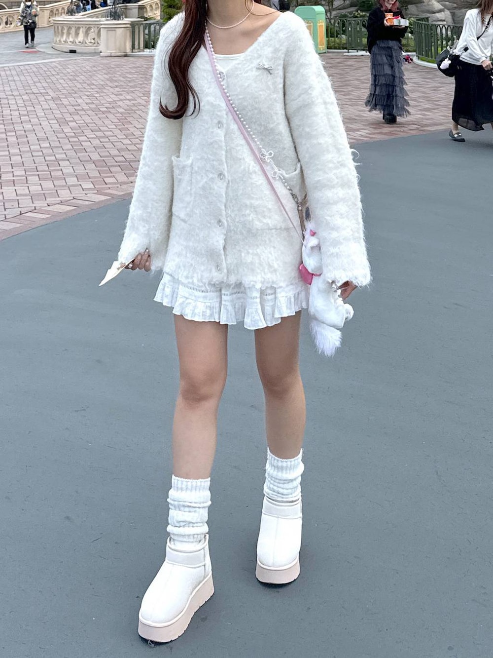 ブラウン系のショルダーバッグ、ホワイト系のTシャツ/カットソー、ホワイト系のブーツを着用したレディースの秋コーディネートの2枚目の写真